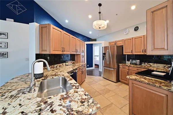 a kitchen with stainless steel appliances granite countertop a stove a sink a refrigerator and a microwave