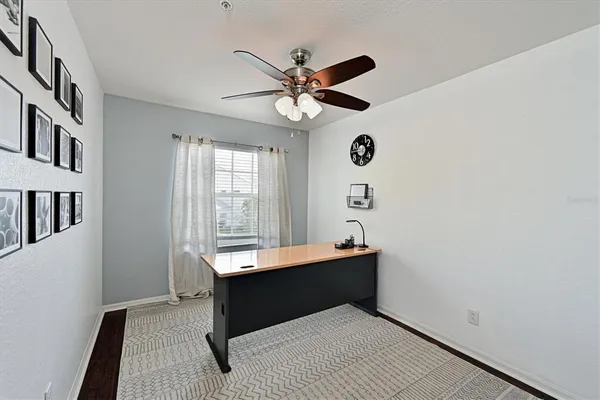a room with chandelier fan and windows