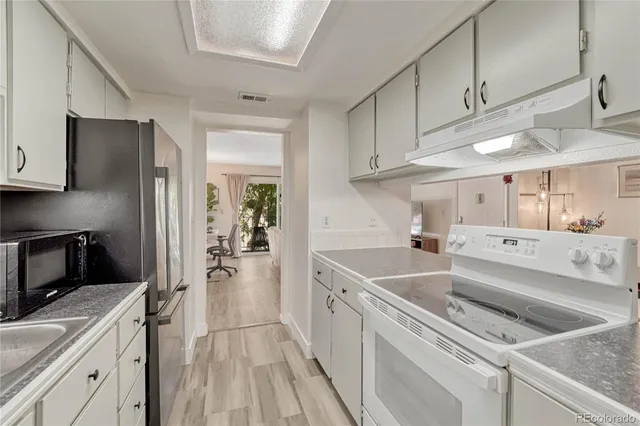 a kitchen with a sink cabinets stainless steel appliances and a window