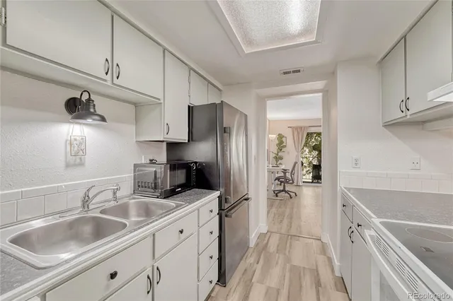a kitchen with granite countertop a sink stove and refrigerator