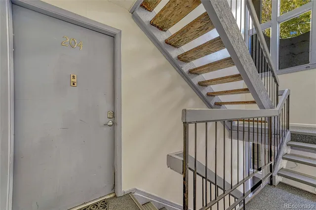 a view of staircase with railing and white walls