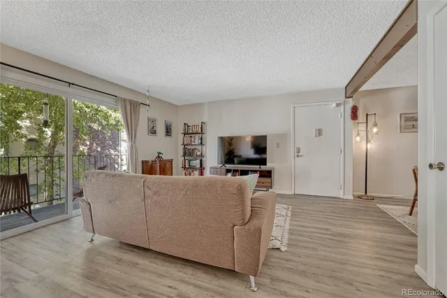 a living room with furniture a flat screen tv and a floor to ceiling window