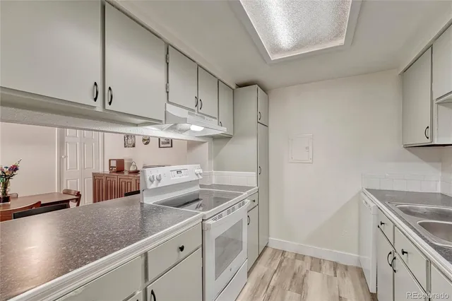 a kitchen with stainless steel appliances granite countertop a sink a stove and a refrigerator