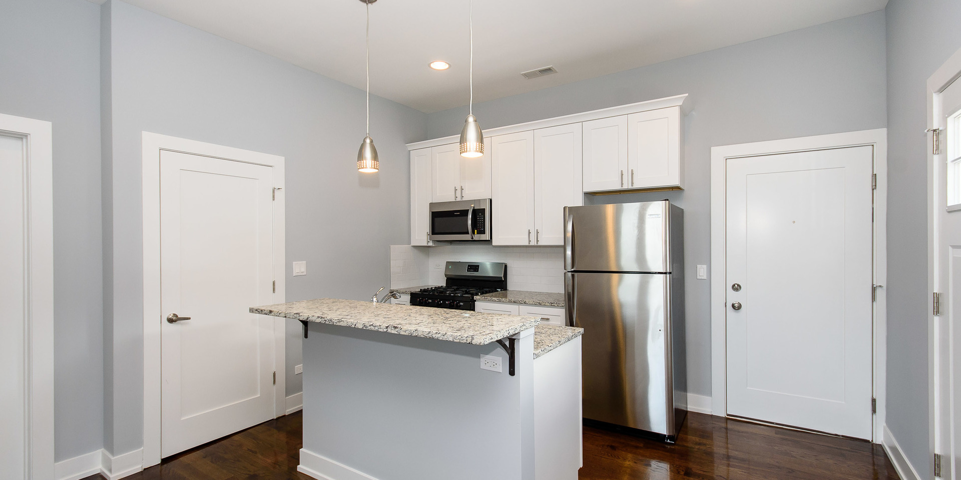 2163 North Bell Avenue, Unit 2F Chicago, IL 60647 - Photo 2 of 12 a kitchen with a refrigerator a microwave a sink and dishwasher