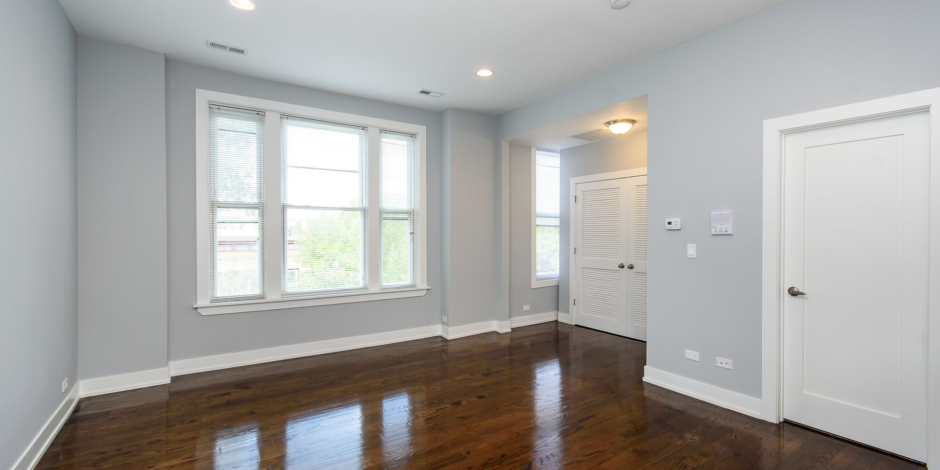 2163 North Bell Avenue, Unit 2F Chicago, IL 60647 - Photo 5 of 12 a view of an empty room with wooden floor and a window