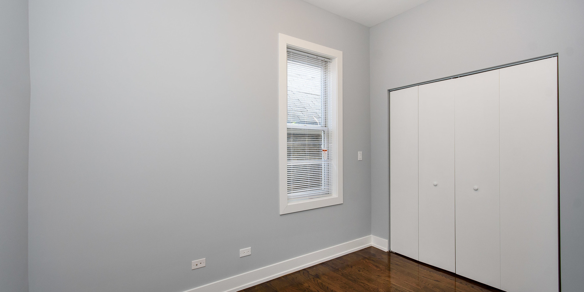 2163 North Bell Avenue, Unit 2F Chicago, IL 60647 - Photo 7 of 12 a view of an empty room with wooden floor and a window