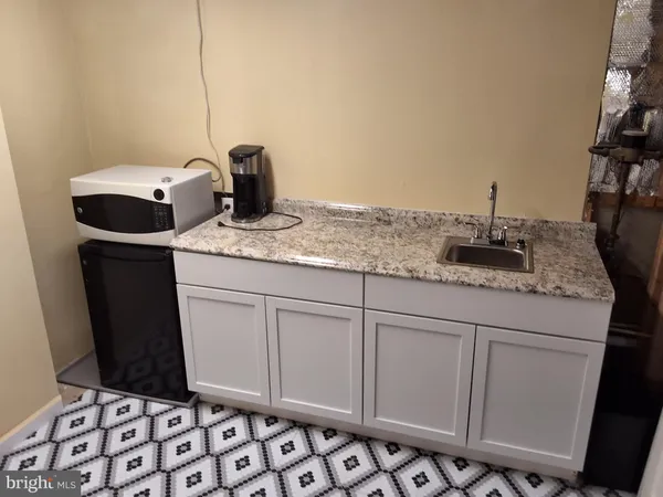 a bathroom with a granite countertop sink and a mirror