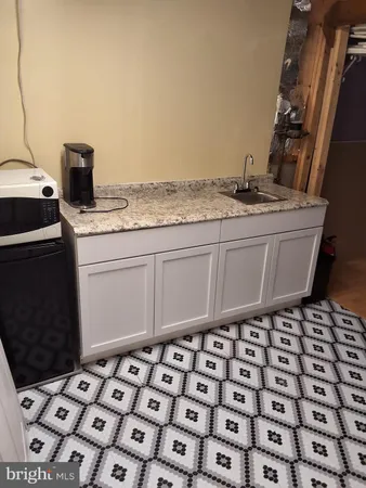 a bathroom with a stove a sink and a mirror