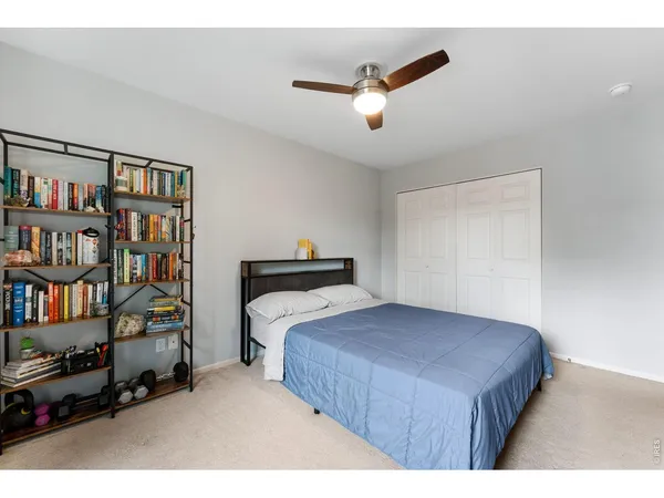 a bedroom with bed and a book shelf