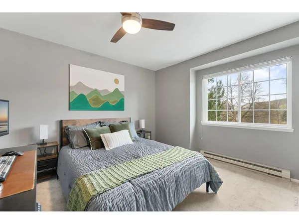a bedroom with a bed and a painting on the wall