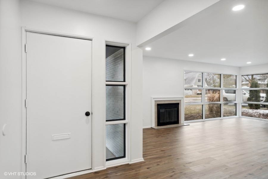 1232 Warrington Road Deerfield, IL 60015 - Photo 2 of 17 an empty room with wooden floor fireplace and cabinet