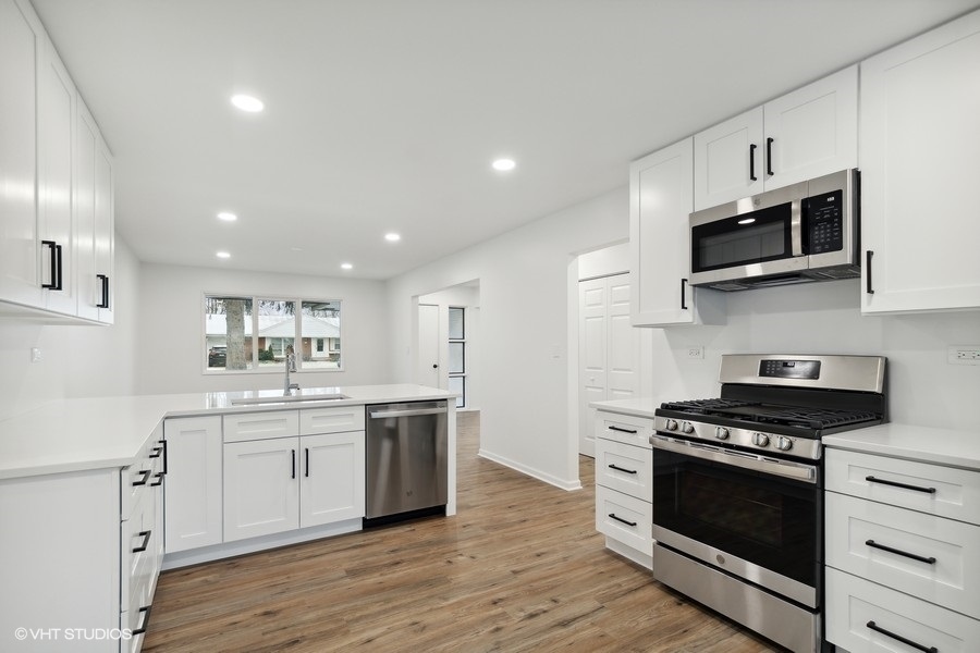 1232 Warrington Road Deerfield, IL 60015 - Photo 4 of 17 a kitchen with stainless steel appliances white cabinets and stove top oven