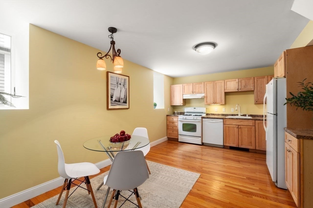 12 Zamora Street Boston, MA 02130 - Photo 23 of 28 a kitchen with stainless steel appliances a dining table chairs and wooden floor