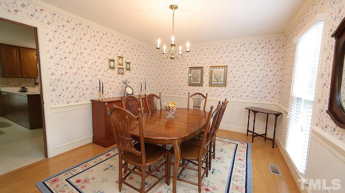 8816 Woodyhill Road Raleigh, NC 27613 - Photo 8 of 30 a view of a dining room with furniture wooden floor and chandelier