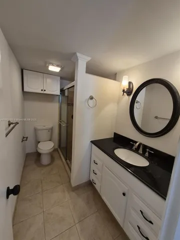 a bathroom with a granite countertop double vanity sink and a mirror