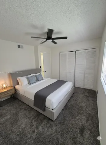a spacious bedroom with a bed and a ceiling fan