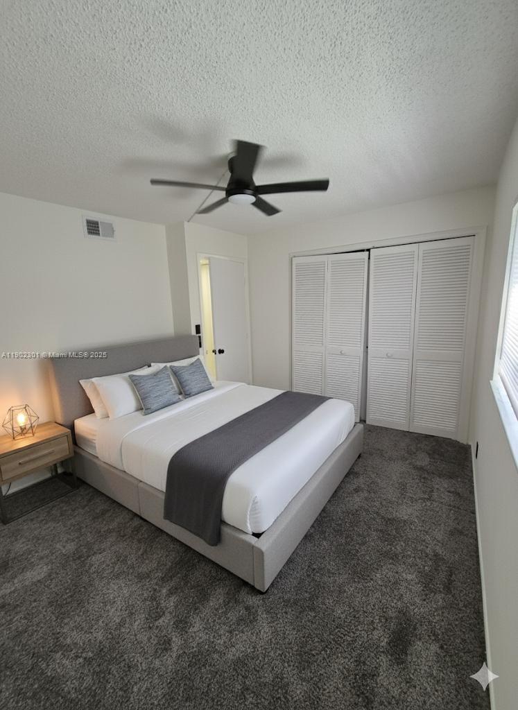 5100 Southwest 64th Avenue, Unit 201A Davie, FL 33314 - Photo 19 of 29 a spacious bedroom with a bed and a ceiling fan