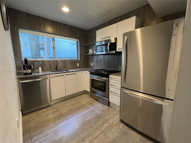 a kitchen with stainless steel appliances a refrigerator sink and microwave