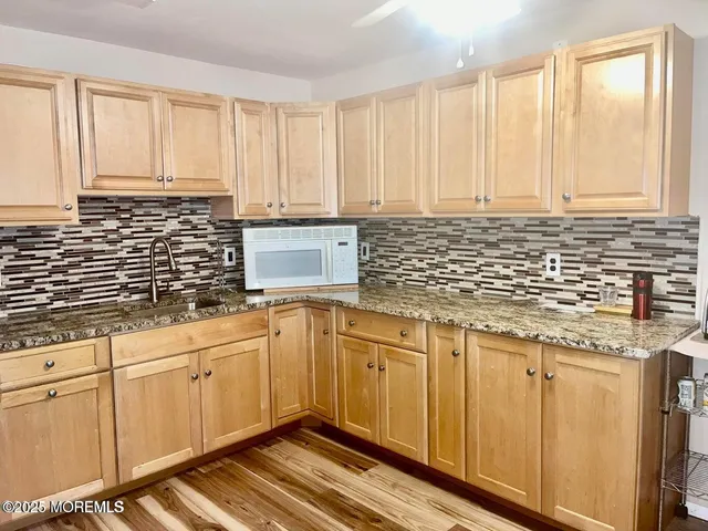 a bed sitting in a bedroom next to a window with wooden floor