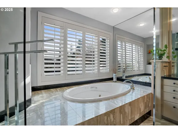 a bathroom with a granite countertop sink and a bathtub