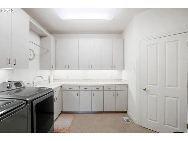 a utility room with sink dryer and washer