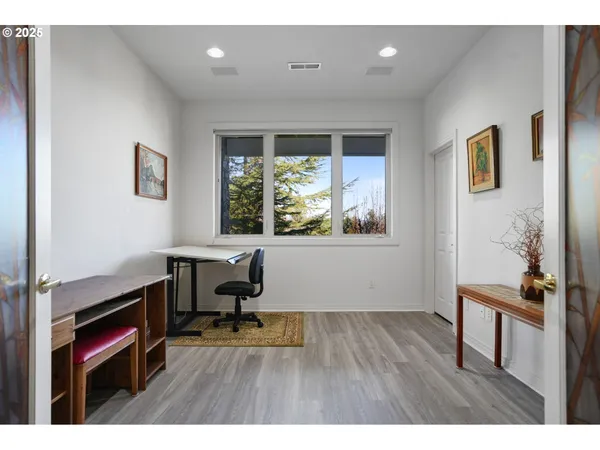 a view of a workspace with furniture and a window