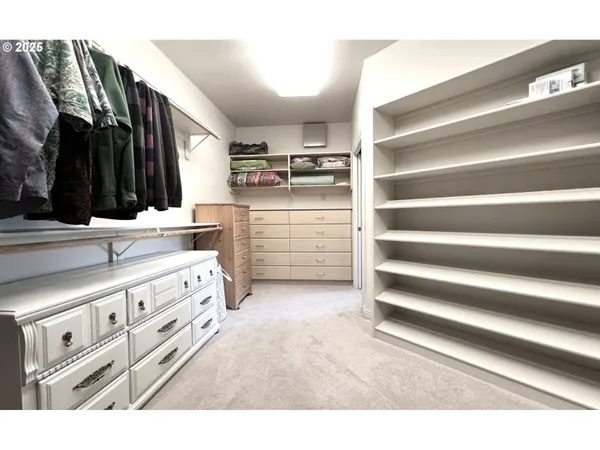 a view of walk in closet with clothes and shoes
