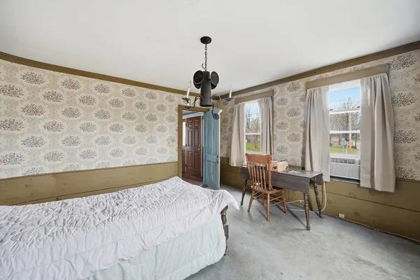a bedroom with a bed and a chandelier
