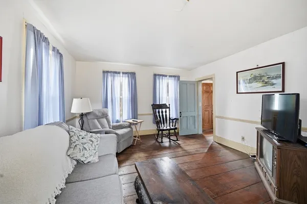a living room with furniture a window and a flat screen tv