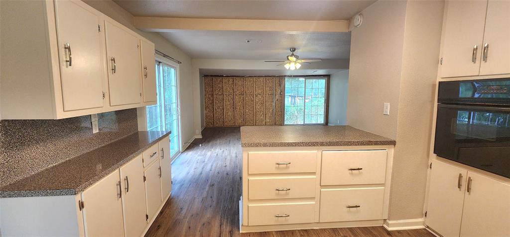 2016 Gavin Road Tool, TX 75143 - Photo 11 of 26 Kitchen featuring white cabinetry with silver-tone hardware, a built-in oven, and a peninsula with countertop seating