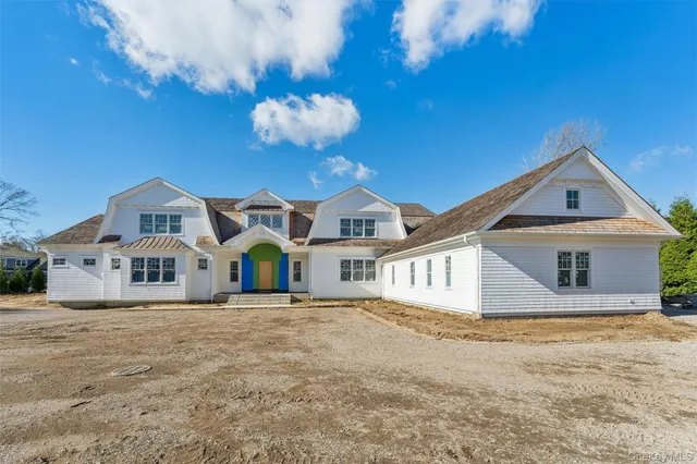 a front view of a house with a large yard and a large tree
