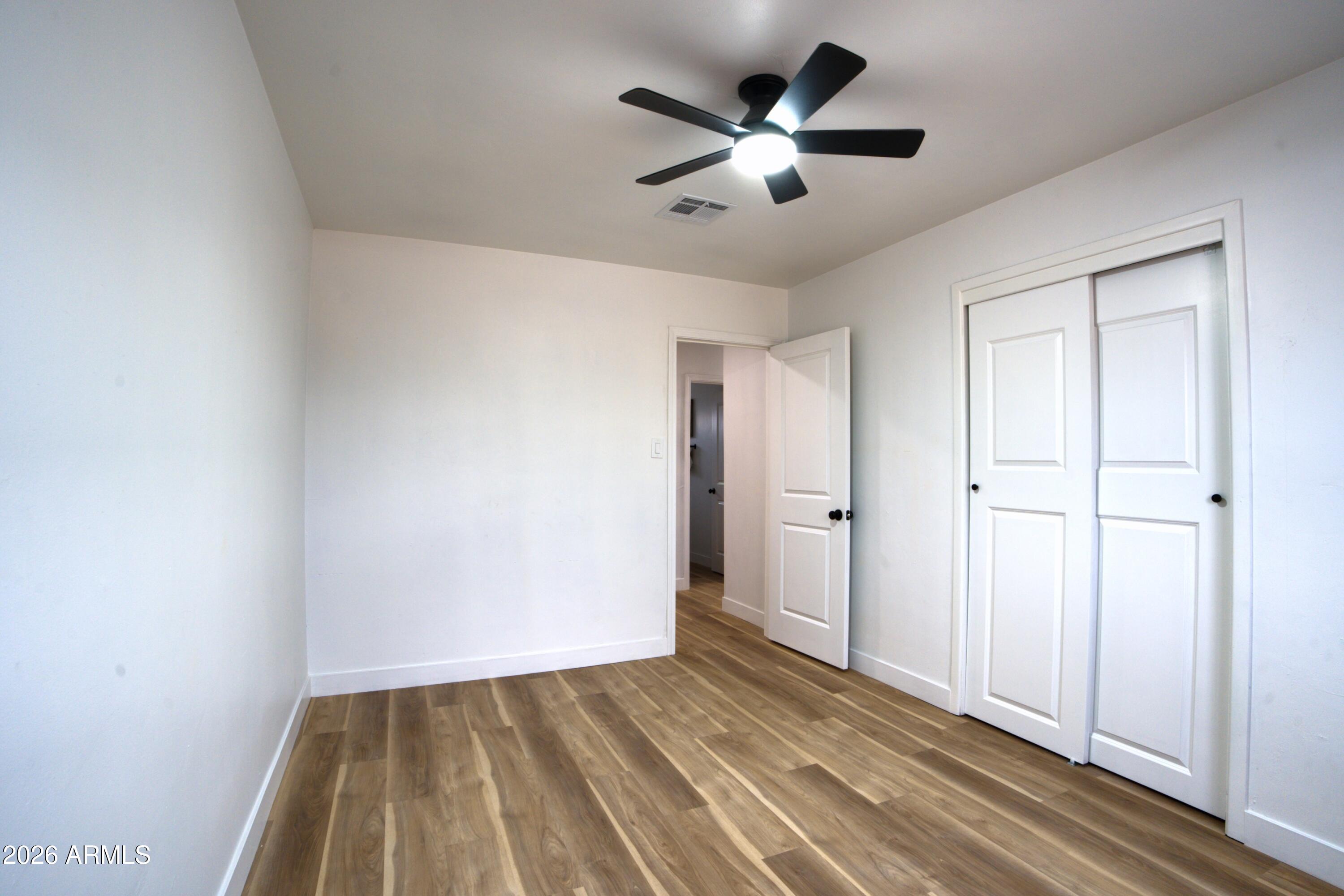 4437 East Almeria Road Phoenix, AZ 85008 - Photo 12 of 20 an empty room with wooden floor and ceiling fan