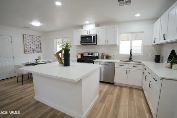a kitchen with a sink a stove a refrigerator and cabinets