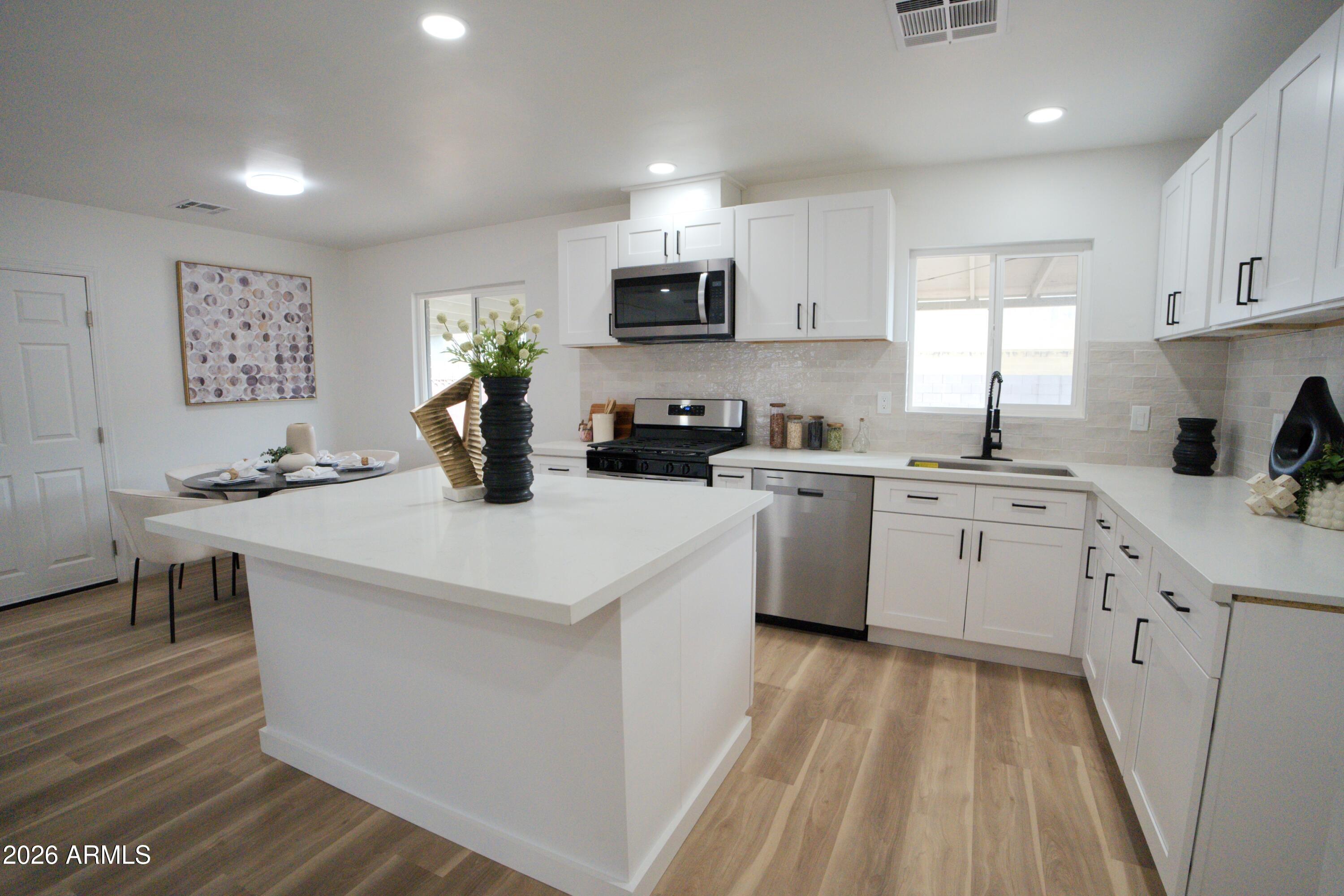4437 East Almeria Road Phoenix, AZ 85008 - Photo 2 of 20 a kitchen with a sink a stove a refrigerator and cabinets