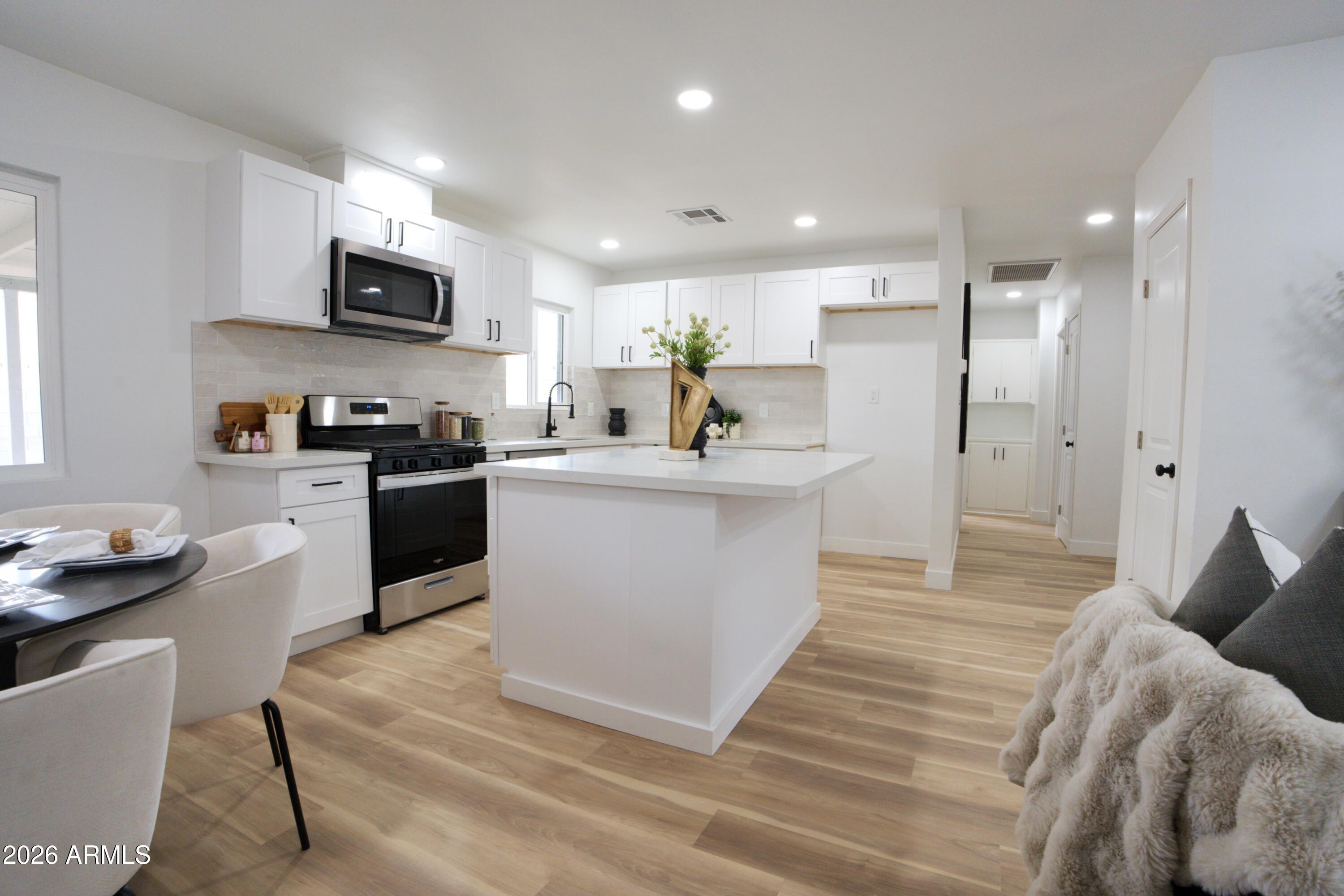 4437 East Almeria Road Phoenix, AZ 85008 - Photo 3 of 20 a living room with stainless steel appliances kitchen island granite countertop a sink cabinets and wooden floor
