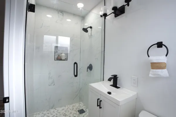 a bathroom with a sink a toilet and shower