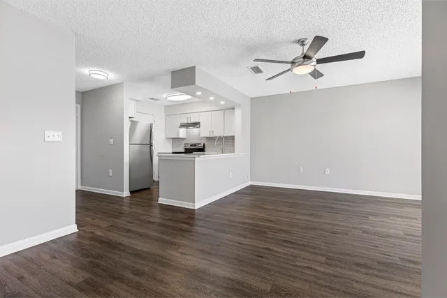 a view of a kitchen with wooden floor a sink and a ceiling fan