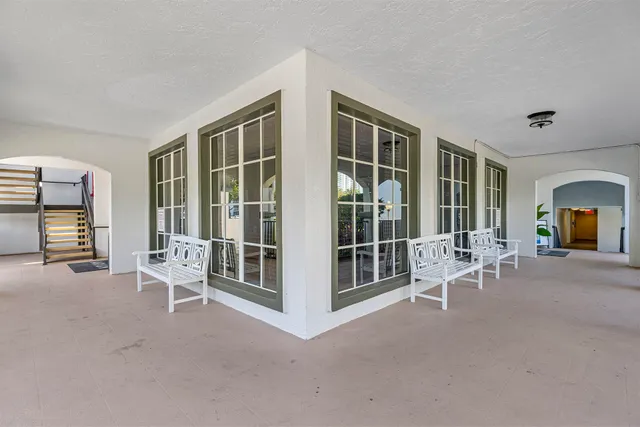 a view of a livingroom with lounge chair and windows