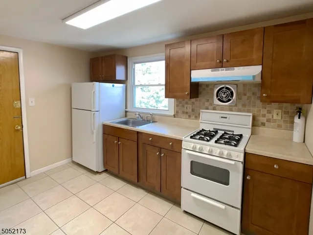 a kitchen with a stove top oven and refrigerator