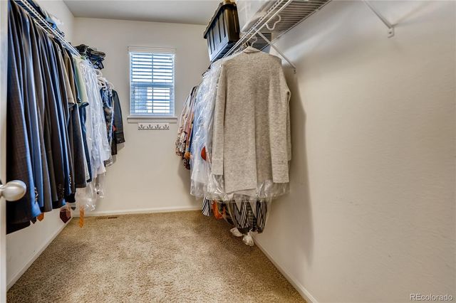 a view of walk in closet with clothes and shoes