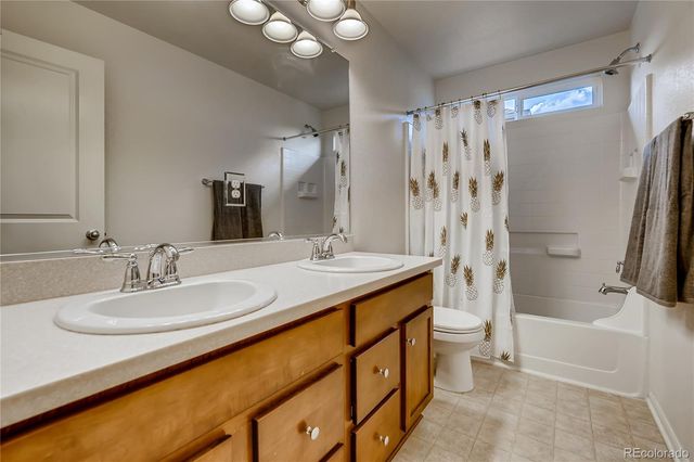 a bathroom with a double vanity sink toilet mirror and shower