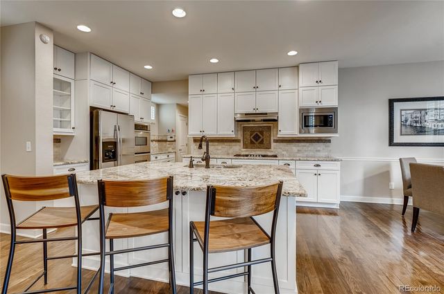 a kitchen with kitchen island granite countertop wooden cabinets and stainless steel appliances