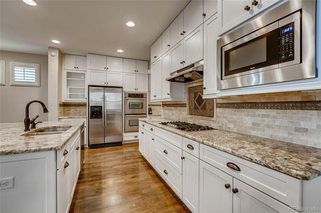 a kitchen with stainless steel appliances granite countertop a stove a sink and a microwave