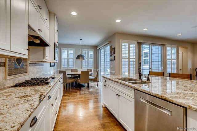 a kitchen with stainless steel appliances granite countertop sink stove and refrigerator