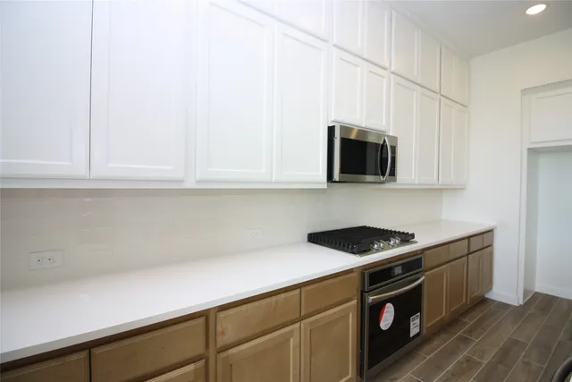 a kitchen with stainless steel appliances a cabinets and a stove top oven