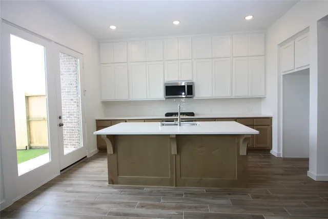 a kitchen with kitchen island a sink stainless steel appliances and cabinets