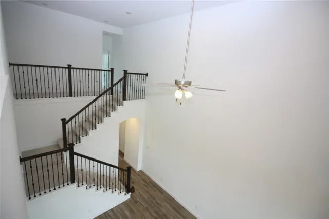 a view of staircase with railing and white walls
