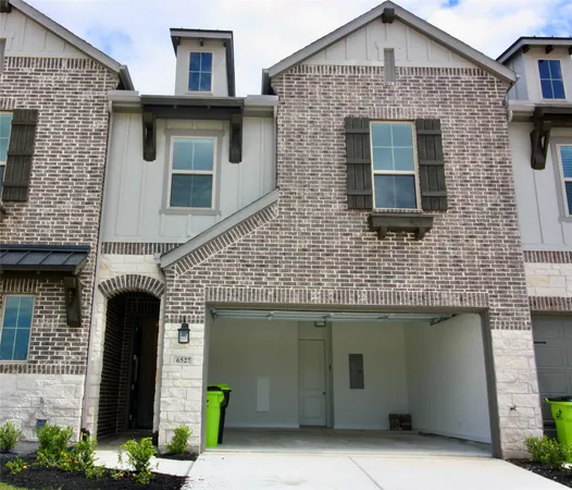 a front view of a house with plants