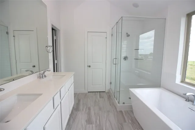 a bathroom with a tub sink shower and two mirror