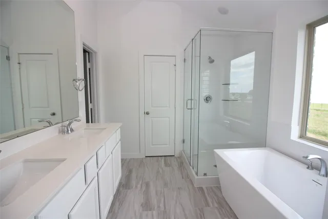 a spacious bathroom with a bathtub shower sink mirror and a bathtub